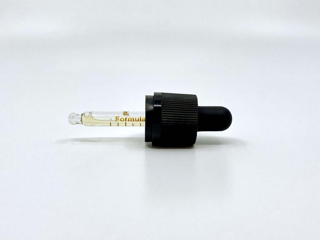 Pipette med CBD olie med appelsin på hvid baggrund
